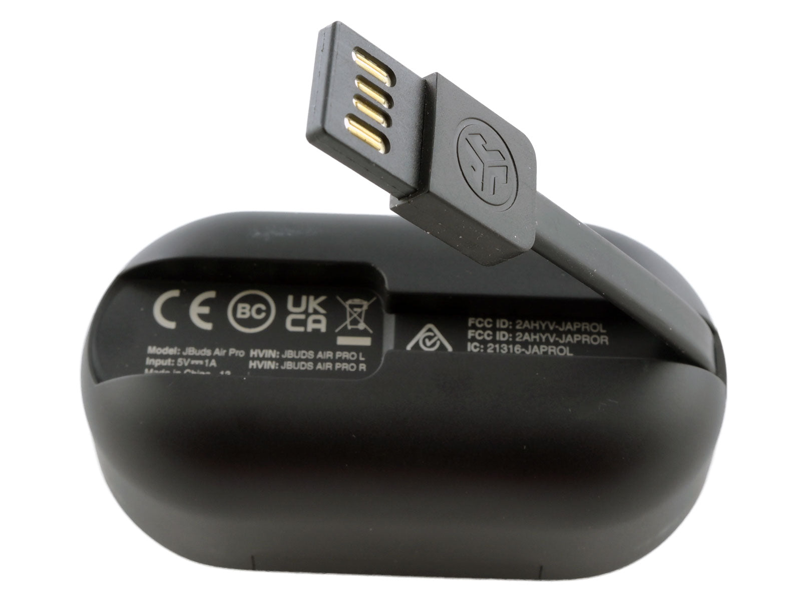 JLab JBuds Air ANC True Wireless Earbuds In-Ear Kopfhörer Ein schwarzes Ladeetui mit integriertem USB-Ladekabel liegt auf der Seite und zeigt verschiedene Zertifizierungssymbole und Texte.
